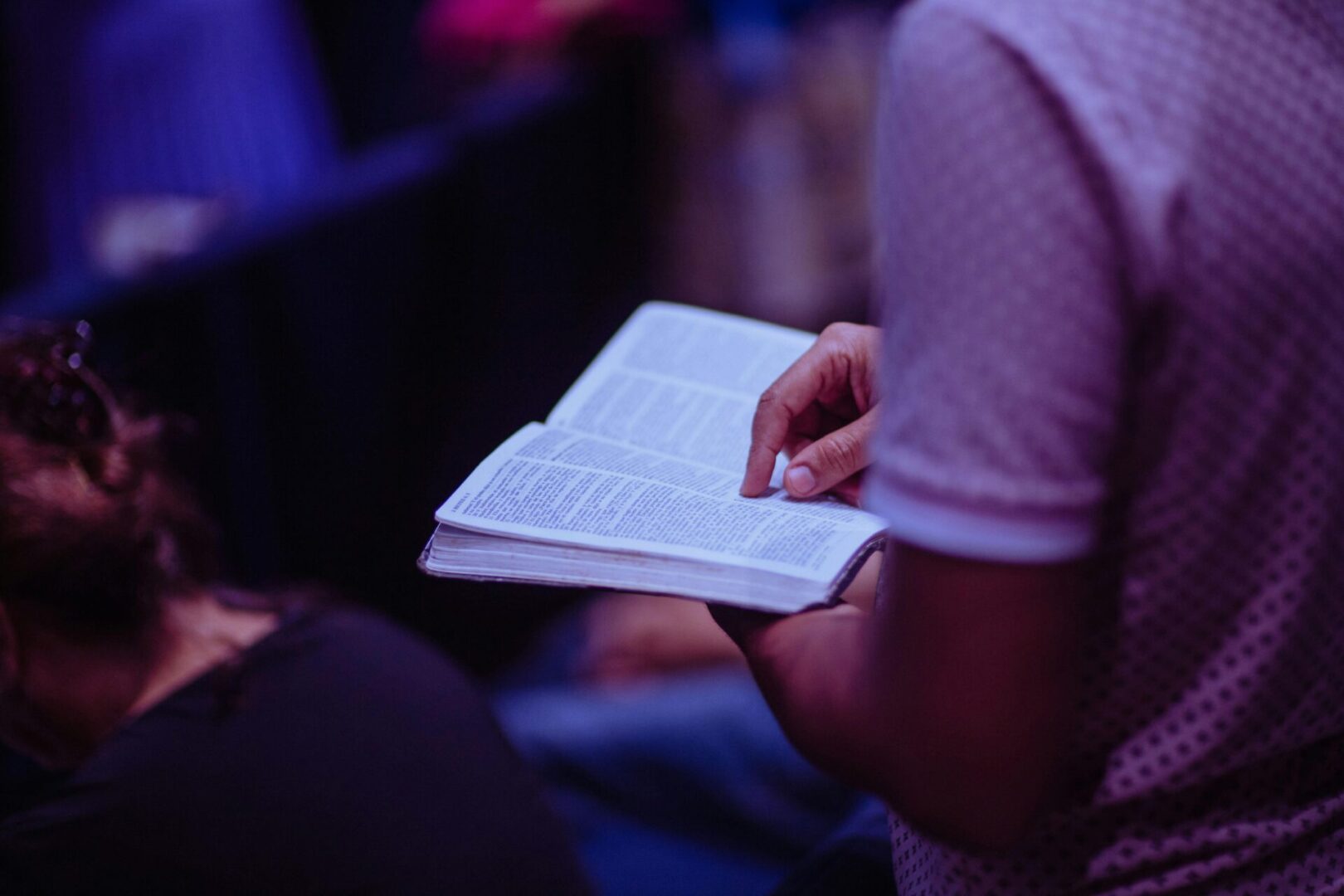 A person holding an open book in their hands.